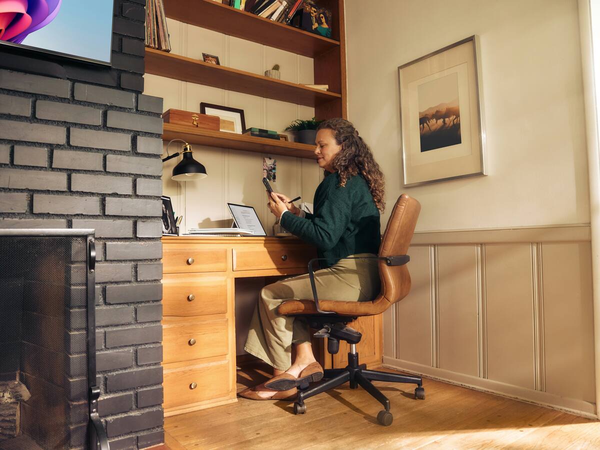 A person working at a laptop on a desk at home.